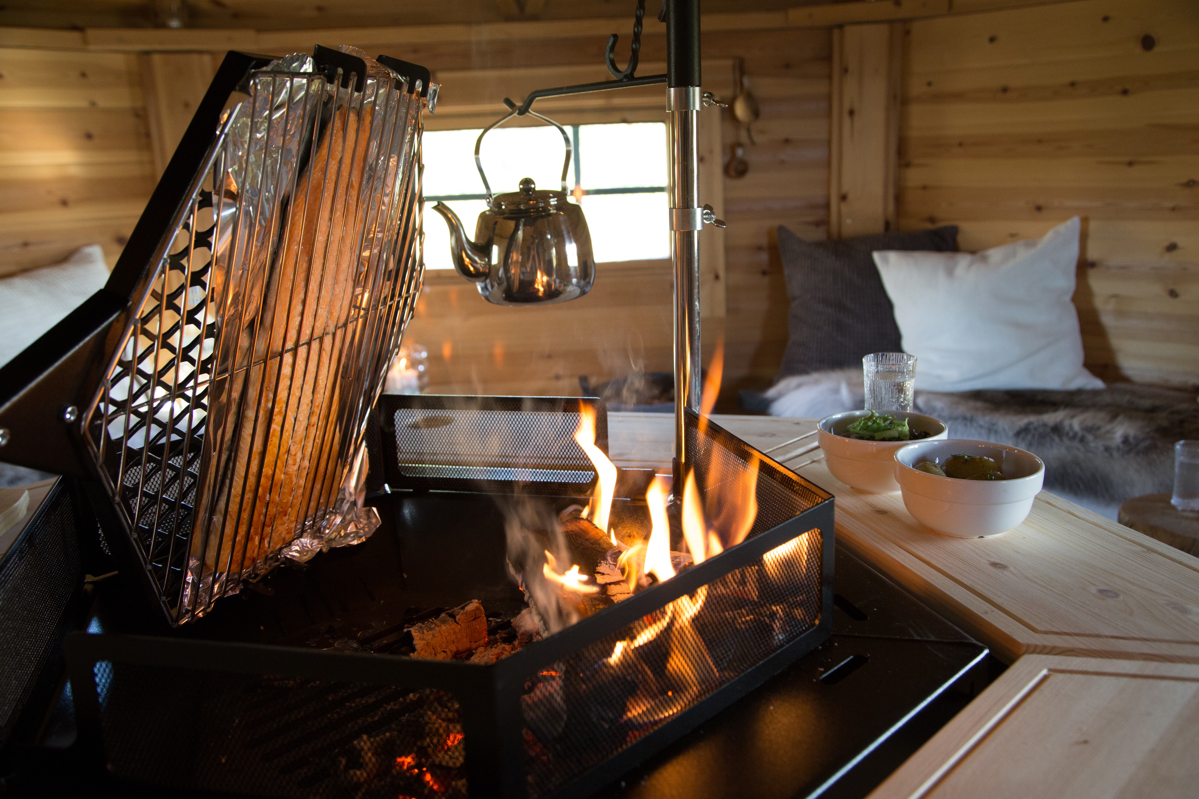 Salmon cooking over wood fire in a BBQ Grill House